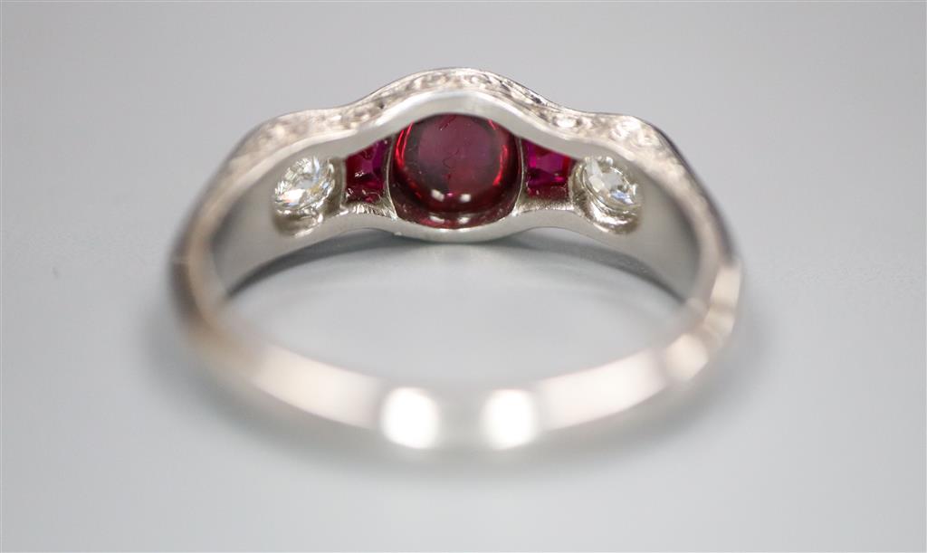 A modern white metal (possibly platinum?), ruby and diamond dress ring,